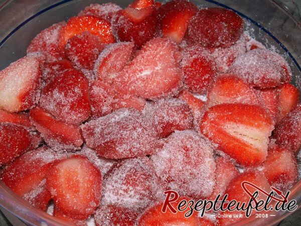 Erdbeeren mit dem Zucker vermengen