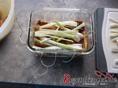 Das Fleisch und die Frühlingszwiebeln werden in die Schüssel geschichtet