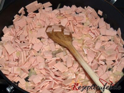 Die Wurst mit den Zwiebeln in Butterschmalz andünsten