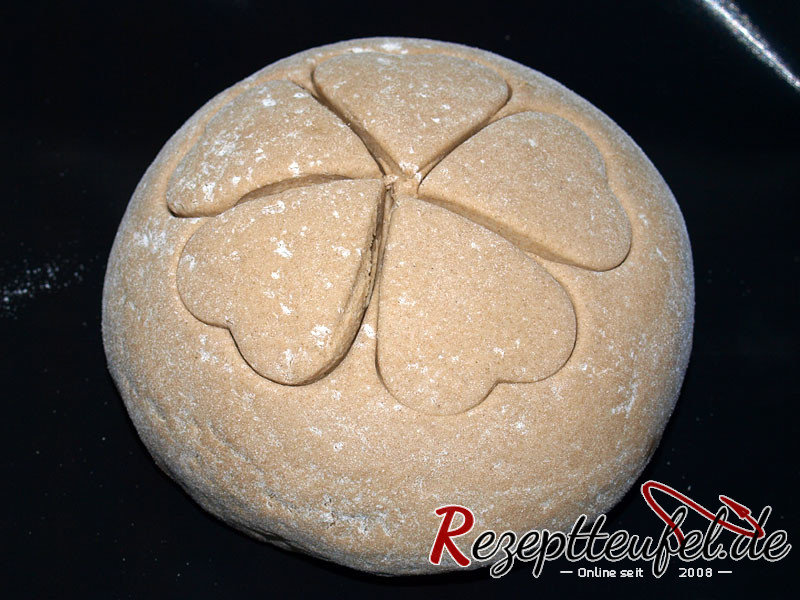 Die Teigkugel mit dem Herzausstecher verziert