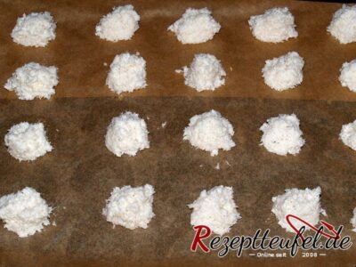 Die Kokosmasse mit 2 Teelöffeln auf ein Backpapier gesetzt