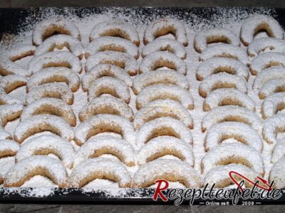 Die Vanillekipferl eng aneinanderlegen und mir der Puderzuckermischung bestäuben