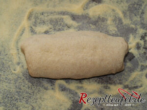 Den Teigling umdrehen (Schluss nach unten) und etwas langgrollen