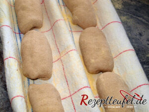 Die Teiglinge auf einem Bäckerleinen oder einem mit Grieß bestreuten Handtuch einschlagen