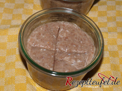 Die Gläser mit der Fleischmasse befüllen und glattstreichen. Eventuell noch ein Kreuz mit einem Teigschaber eindrücken