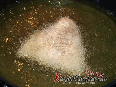Das mehlierte Karpfenfilet wird in viel heißem Fett ausgebacken