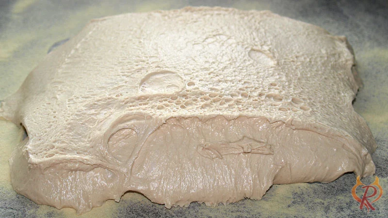 Teig auf die mit Grieß bestreute Arbeitsfläche gekippt