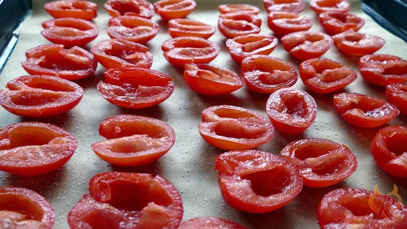 Halbierte, entkernte und abgetrocknete Tomaten auf dem Blech