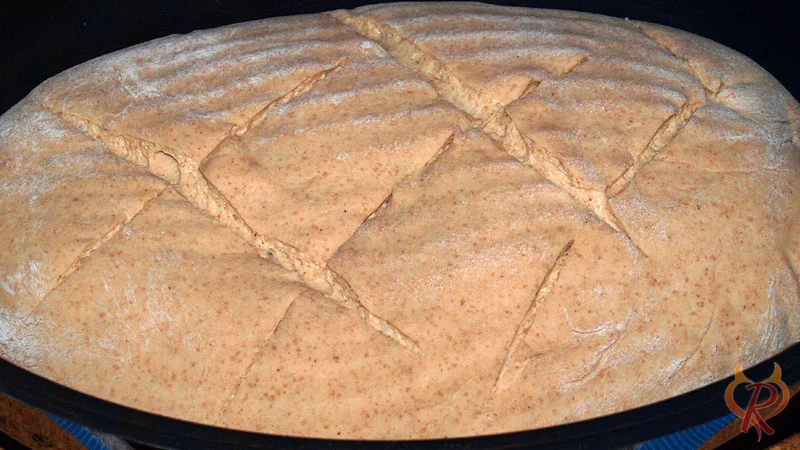 Der Brotteig ist in den heißen Bräter gestürzt und eingeschnitten