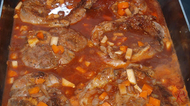 Die Beinscheiben in das mit Wein und Brühe aufgegossene Gemüse geben