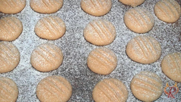 Die gebackenen Schneeflocken-Plätzchen nach dem Backen mit Puderzucker bestäuben