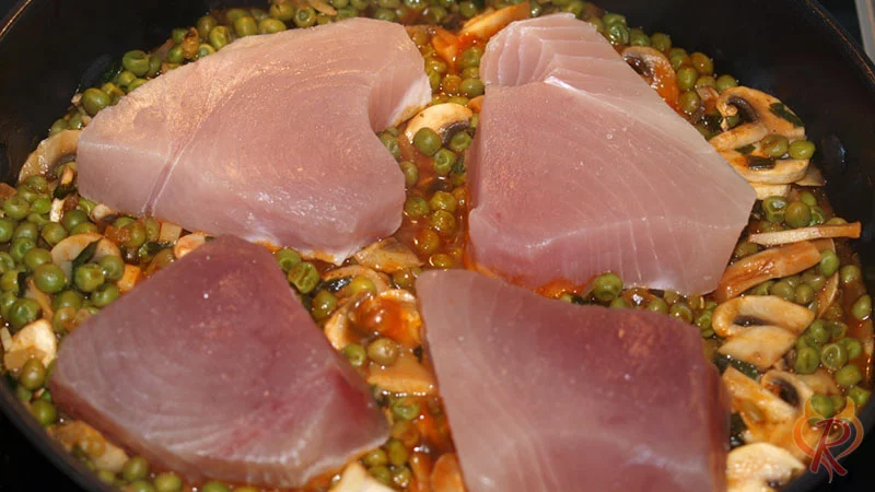 Der Thunfisch wird auf das Gemüse mit Soße gegeben