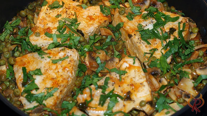 Die fertigen Thunfischfilets auf Erbsen gegart und mit Petersilie bestreut